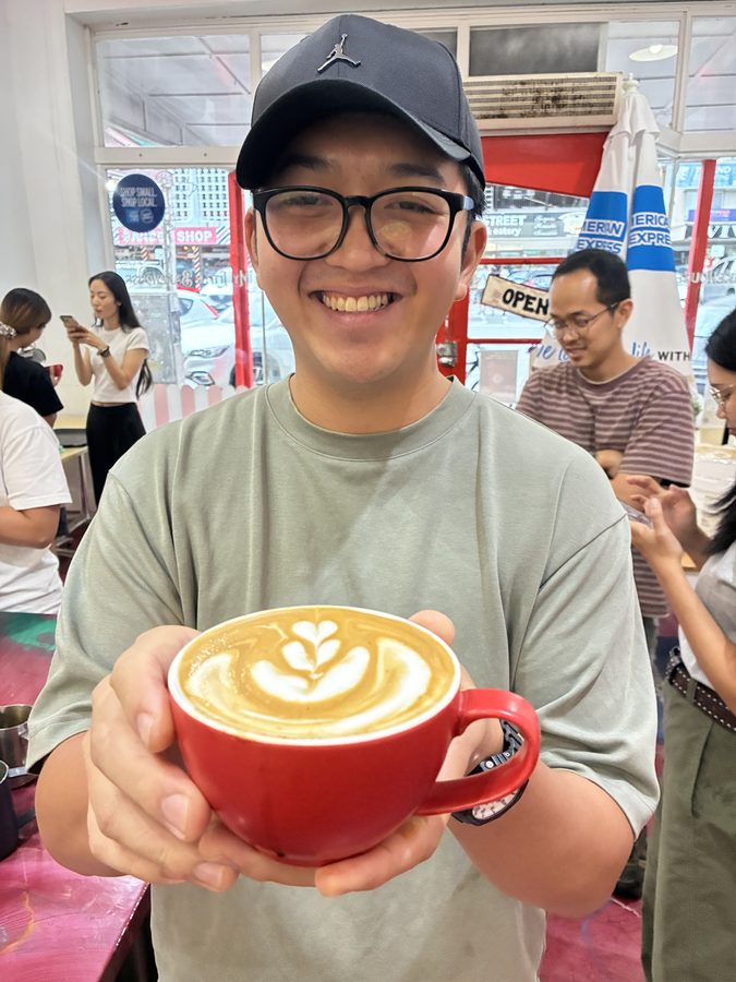 Student holding red cup latte art