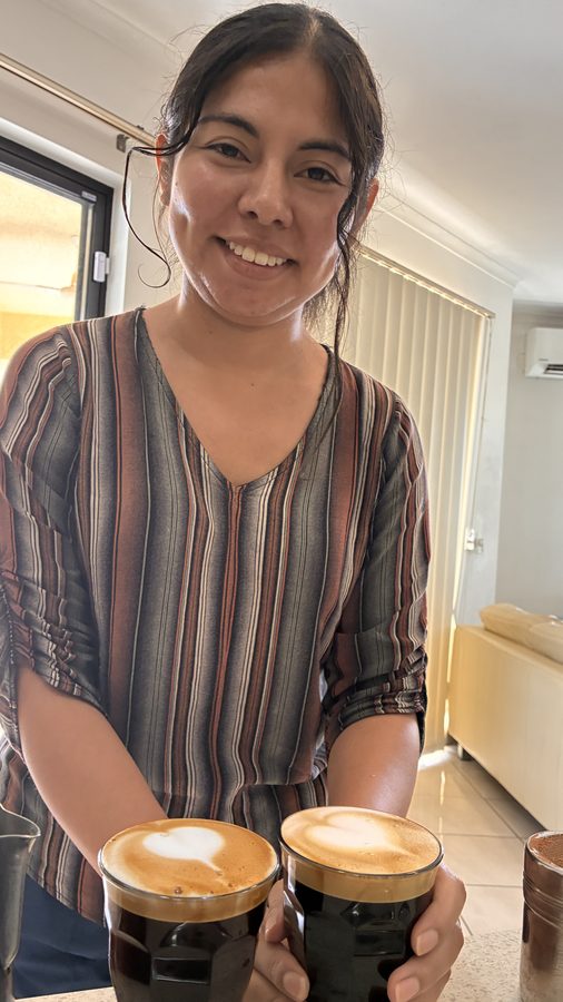 Student holding two coffees with latte art