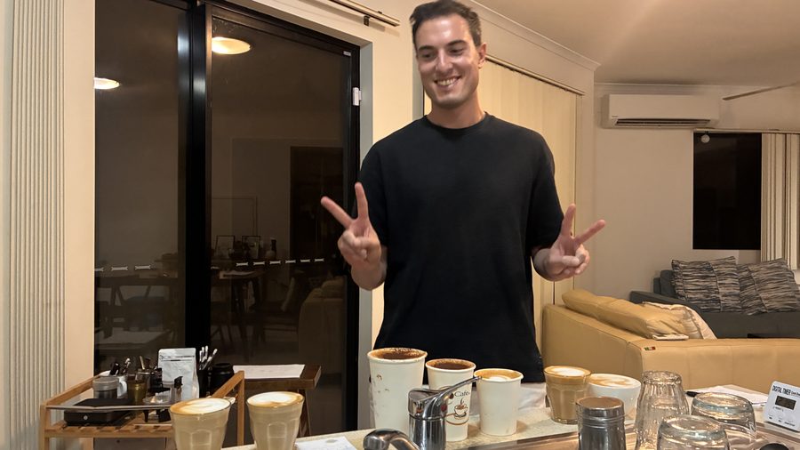 Student with a full spread of latte art coffees