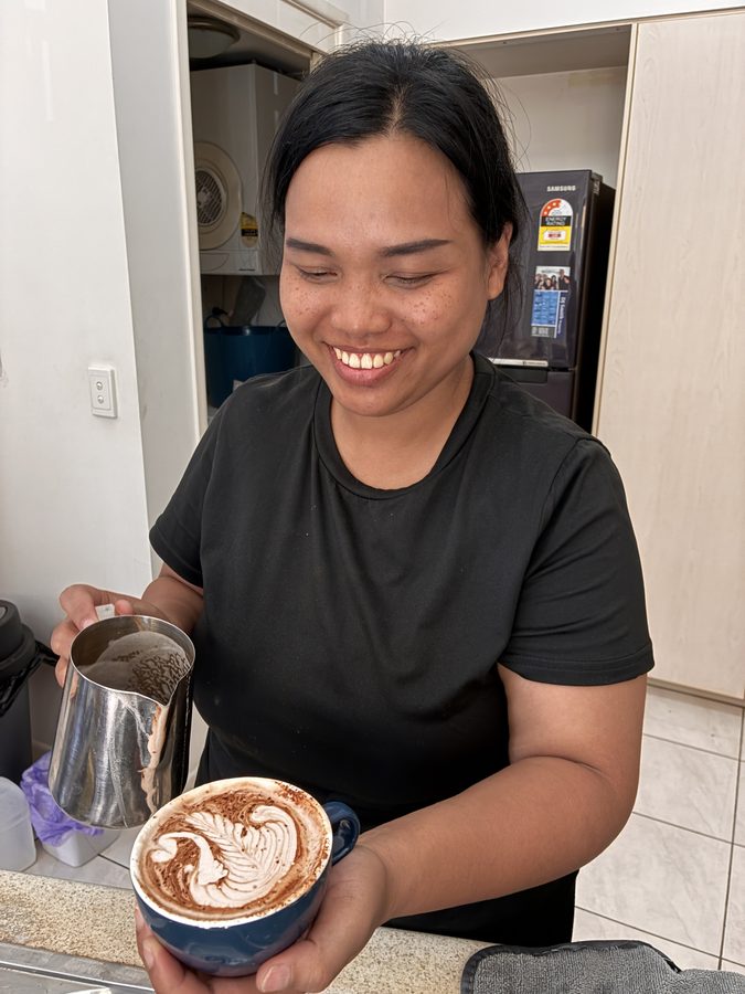 Student holding their finished coffee