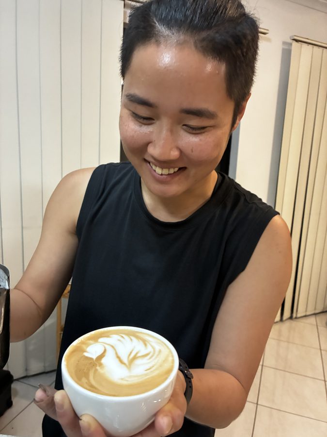 Student smiling with their finished coffee