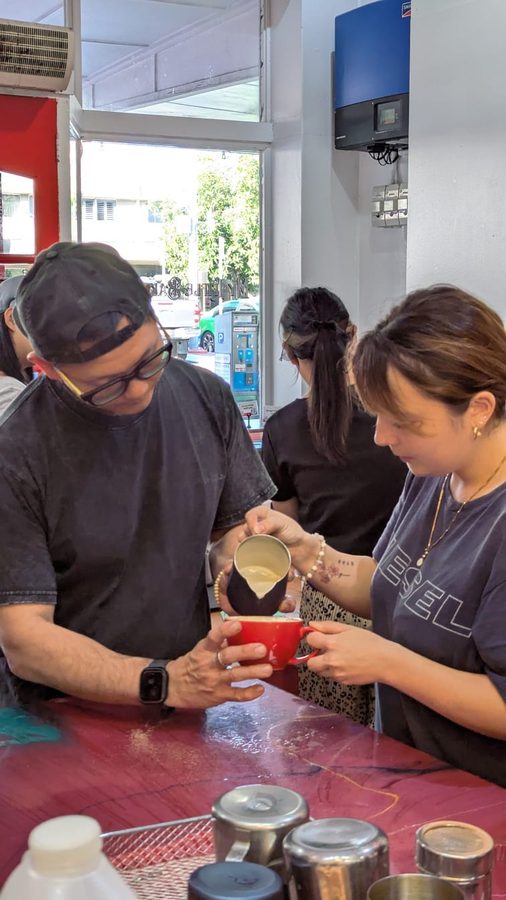 Jimmy teaching a student latte art technique